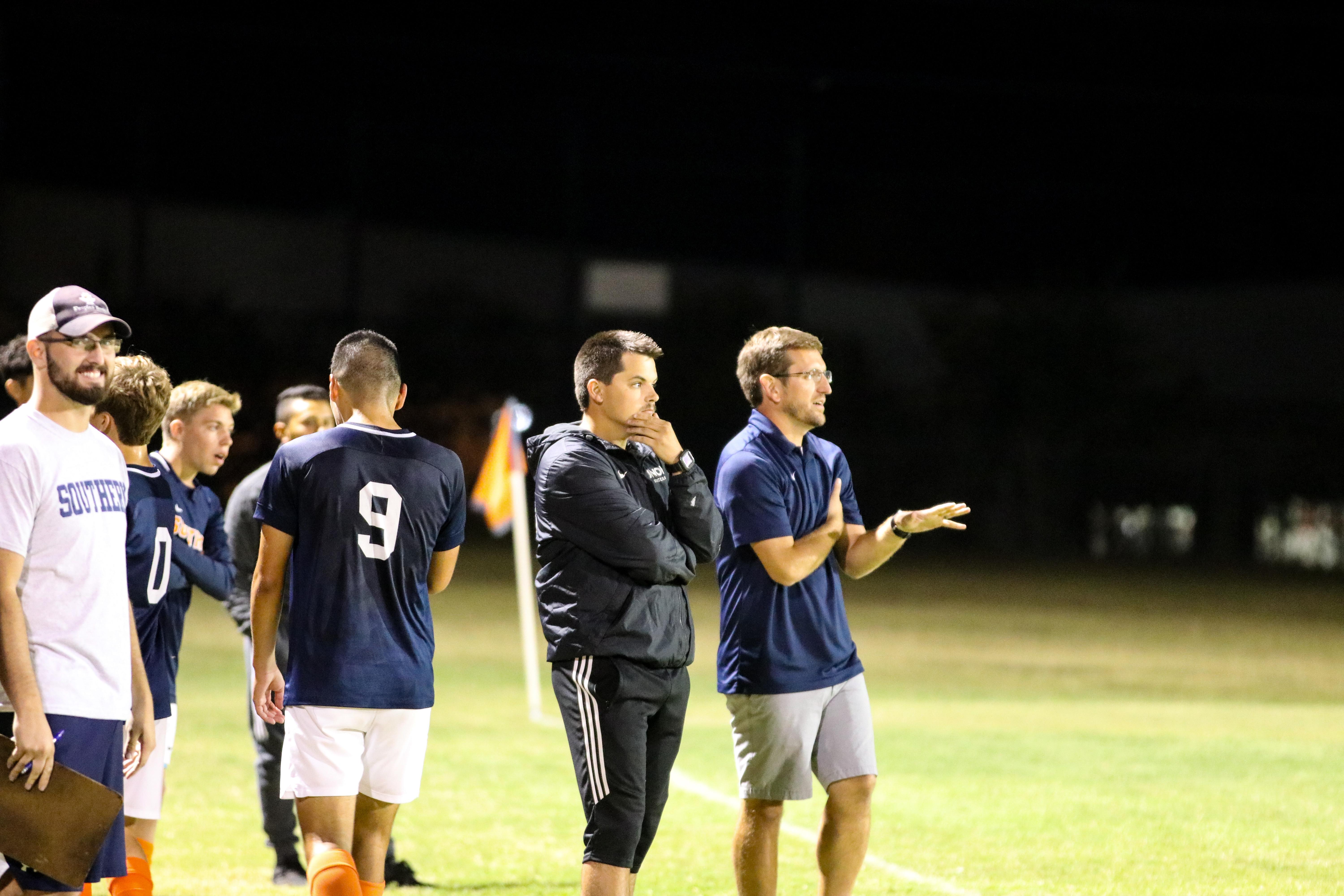 Andrew coaching from the sideline under the lights, 2019